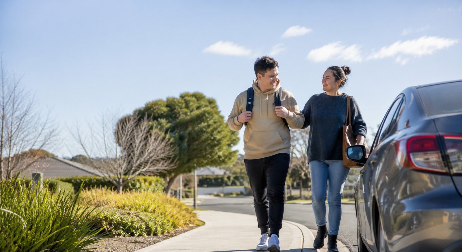 A support worker and participant setting off together on a sunny suburban street, the participant relaxed and ready for the day
